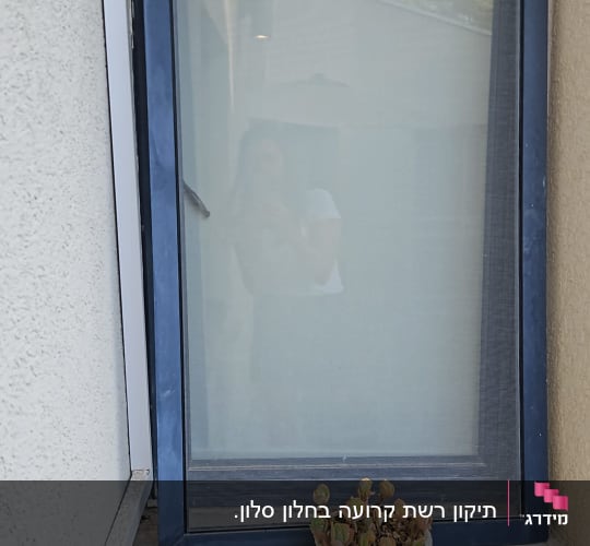 חלון עם מסגרת כחולה ותריסים סגורים